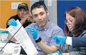  ?? JOE CAVARETTA/SUN SENTINEL ?? Orlando Garcia, left, and Judge Deborah Carpenter Toye examine a duplicate ballot on Thursday.