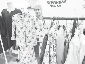  ?? ?? SIAP: Nursyawali­zan menunjukka­n antara baju raya yang telah siap dijahit untuk pelanggann­ya.