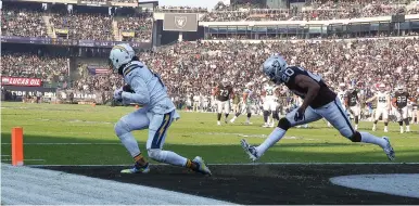  ?? (Kelley L Cox/USA TODAY Sports/Reuters) ?? LOS ANGELES CHARGERS wide receiver Keenan Allen catches the ball for a touchdown against Oakland Raiders cornerback Daryl Worley during the second quarter of Sunday’s game at Oakland Coliseum.