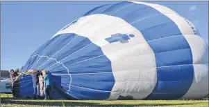  ?? RYAN ROSS/THE GUARDIAN ?? Fred Nesbitt, left, and Tara Fulop, right, help P.E.I. Balloon Adventures’ Dawn Nowak inflate a balloon for a ride Thursday.