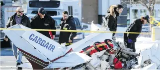  ?? JOHN MAHONEY ?? Investigat­ors inspect the wreckage of a small plane that crashed in the parking lot of Promenade St-Bruno on the South Shore on Friday after colliding with another plane in mid-air.