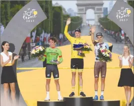  ?? The Associated Press ?? Tour de France winner Chris Froome of Britain, wearing the yellow jersey, second place Rigoberto Uran of Colombia, left, and third place Romain Bardet of France, right, celebrate on the podium after the 21st and last stage of the cycling race in Paris,...