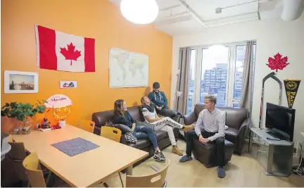  ?? PHOTOS: CHRISTINNE MUSCHI ?? Mathilde Granger, left, of Quebec, Jessica Currey (New Zealand), Mohamed Ali (Kenya) and Florian Montaufier (France) chat in the common room at La Marque in downtown Montreal. “The best thing about living here is learning about other countries,” says...