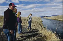  ?? GILLIAN FLACCUS — THE ASSOCIATED PRESS FILE ?? Farmer Ben DuVal with his wife, Erika, and their daughters, Hannah, third from left, and Helena, fourth from left, stand near a canal for collecting run-off water near their property in Tulelake.