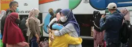  ?? SALMAN TOYIBI/JAWA POS ?? MOBILITAS: Penumpang bus tujuan Sumatera berpamitan dengan anggota keluarga di Terminal Kampung Rambutan, Jakarta Timur, kemarin (16/7).