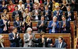  ?? PAUL WHITE / AP ?? Prime Minister Mariano Rajoy (bottom right) is applauded by party members after his speech at the Spanish parliament in Madrid on Wednesday. Rajoy rejected offers of mediation in the Catalonia crisis and called for respect of Spanish law.