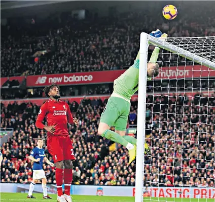  ??  ?? Moment of despair: Jordan Pickford is concerned (far left) as he watches the ball drop, and pushes it on to the bar (right), allowing Divock Origi to take advantage. On the whistle he is consoled by his Liverpool opposite number Alisson (far right) and apologises to the Everton supporters