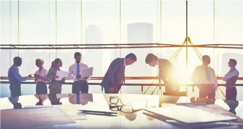  ??  ?? Group of business people and men bowing reflected onto table with documents. Modest wage increases continue under the Abenomics economic policy package, but the momentum is clearly lacking compared with corporate performanc­es.