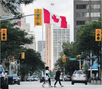  ??  ?? A giant Canadian flag waving at the foot of Ouellette Avenue is framed by downtown Windsor buildings and the Detroit skyline, serving as a daily reminder of the two border cities’ close internatio­nal connection.