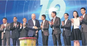  ??  ?? Najib (fourth left) shakes hands with Ma (fifth left) after Alibaba officially announced the establishm­ent of an e-hub under the eWTP initiative together with MDEC. — Bernama photo