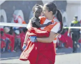  ?? ?? Una trabajador­a de Cruz Roja sostiene a un niño migrante, en Canarias.