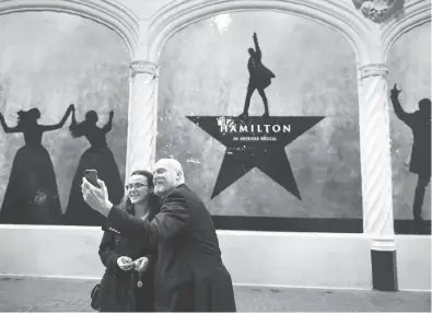  ?? Photos by Michael Short / Special to The Chronicle ?? Emma and James Pixton of Alameda take a picture in front of a “Hamilton” sign before the musical’s first public performanc­e at the Orpheum Theatre in San Francisco. Scoring tickets has been a tough task for many fans.