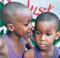  ?? JERMAINE BARNABY ?? Shaneil Gilespie (left) whispers to friend Andre Burke in Kingston on November 28.