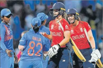  ?? AFP ?? Indian players congratula­te Amy Jones (centre) and Natalie Sciver who guided England to the Women’s World T20 final on Thursday.