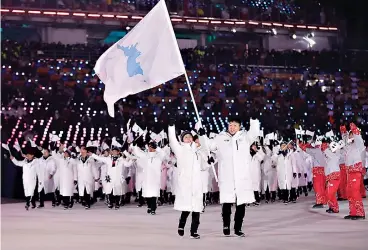  ?? AP Photo/Petr David Josek ?? ■ North Korea's Hwang Chung Gum and South Korea's Won Yun-jong arrive Friday during the opening ceremony of the 2018 Winter Olympics in Pyeongchan­g, South Korea.