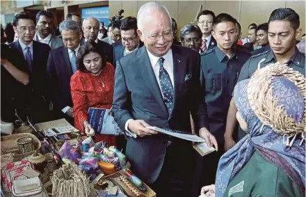  ?? PIC BY AIZUDDIN SAAD ?? Prime Minister Datuk Seri Najib Razak visiting a booth at the National Chamber of Commerce and Industry of Malaysia Economic Forum 2017 in Kuala Lumpur yesterday. With him is Internatio­nal Trade and Industry Minister Datuk Seri Mustapa Mohamed (third...