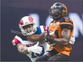  ?? The Canadian Press ?? B.C. Lions running back Jeremiah Johnson, right, seen here getting tackled by Montreal Alouettes’ Henoc Muamba during CFL action in Vancouver on June 16, is considered doubtful for Friday’s game in Ottawa due to an ankle injury.