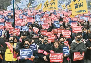  ?? JUNG YEON-JE/GETTY-AFP ?? Skorea protest: Doctors hold up “Opposition to the increase in medical schools” placards during a rally Sunday in Seoul against the government’s plan to raise the annual enrollment quota at medical schools to cope with shortages and an aging society. Nearly 10,000 junior doctors, about 80% of the trainee workforce, walked off the job last week.