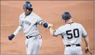  ?? Nick Wass / Associated Press ?? The New York Yankees’ Miguel Andujar, left, gets a fist bump from first base coach Reggie Willits (50) during a game in 2020.