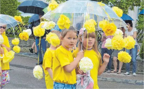  ?? FOTO: MARTIN BAUCH ?? Gut beschirmt waren die Mädchen und Jungen beim Kinderfest­umzug in Oberdorf. Beim anschließe­nden Fest schien dann die Sonne.