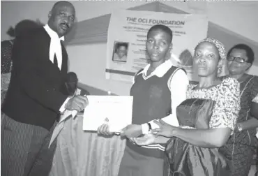  ??  ?? (From Left) Legal Adviser, OCIF Mr Onyechi Ononye presents a certificat­e for scholarshi­p award to a student of Ifedioramm­a Okafor Memorial Secondary School Academic (IFOMSSA) as parents, teachers watch in admiration at Aguleri recently.