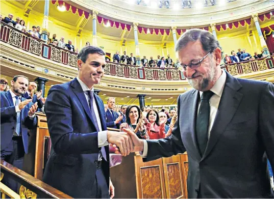 ??  ?? Pedro Sánchez, left, Spain’s new prime minister, shakes hands with Mariano Rajoy, the ousted premier, as Spanish politician­s acclaim the historic vote