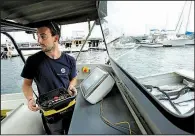 ?? AP/STEVE SENNE ?? Frank Marino, an engineer with Sea Machines Robotics, uses a remote control belt pack to control a self-driving boat in Boston Harbor in mid-August.