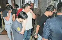  ??  ?? 6名被告被庭警押往扣­留室等候保外时，遮盖脸部，以避免脸孔见报。