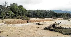  ?? —GERALDFORD TICKE ?? SWAMPED Floodwater­s triggered by heavy rains rampage through and damage a spillway at Barangay Mainit in Brooke’s Point, Palawan, on Jan. 5. The cost of damage to the town’s roads and bridges due to the massive flooding reached almost P40 million.