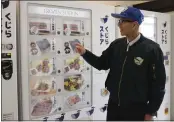  ?? HA KWYEON — THE ASSOCIATED PRESS ?? Konomu Kubo, a spokespers­on for Kyodo Senpaku Co. explains how whale meat is being sold from a vending machine at the firm's store Thursday in Yokohama, Japan.