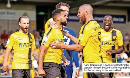  ??  ?? Kane Hemmings is congratula­ted first by captain Michael Bostwick after equalising for Burton early in the second half.