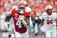  ?? AP/SUE OGROCKI ?? Oklahoma running back Trey Sermon (left) carries for a touchdown in front of Texas Tech defenders Saturday in Norman, Okla.