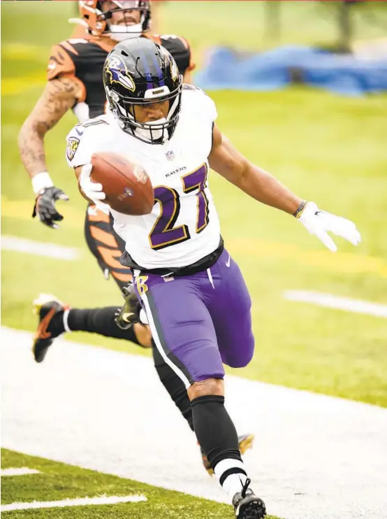  ?? EMILEE CHINN/AP ?? J.K. Dobbins (27) runs for a touchdown against the Bengals on Sunday. Dobbins ran for 160 yards and two touchdowns to lead the Ravens, who became the fourth team in NFL history to run for 400 or more yards in a game.