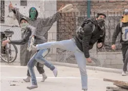  ?? — PTI ?? Youth throw stones at police personnel during clashes at Nowhatta in Srinagar on Friday over the recent civilians killings in Shopian.