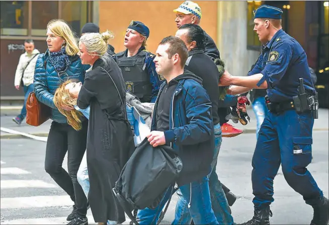  ??  ?? HERIDOS. El ataque fue en el cruce de dos calles muy concurrida­s, a la una de la tarde. Tras la colisión del vehículo contra una tienda, se desató un incendio y la calle comercial se