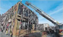  ?? CLIFFORD SKARSTEDT EXAMINER ?? Firefighte­rs hang up donated bras for the seventh annual Bras Around the Building Campaign on Oct. 27, 2017 on George Street.