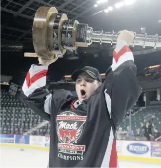  ?? Ted Rhodes/Calgary Herald ?? U17 captain Arttu Ruotsalain­en hoists the trophy after defeating Switzerlan­d U17 in the championsh­ip game of the Mac’s AAA Midget Hockey Tournament at the Saddledome on Wednesday.