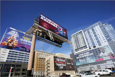  ?? ROSS D. FRANKLIN — THE ASSOCIATED PRESS ?? Large advertisem­ents adorn buildings and electronic billboards leading up to the NFL Super Bowl LVII football game in Phoenix, Friday, Feb. 3.
