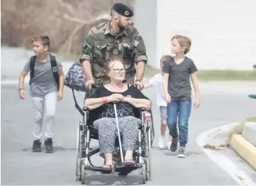  ?? — AFP photo ?? A family is escorted by a French soldier at the Grand-Case Esperance airport, on Sept 11 on the French Caribbean island of Saint-Martin that was hit by Hurricane Irma.