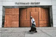  ?? Spencer Platt / Tribune News Service ?? People walk past a closed Victoria’s Secret store in a Manhattan shopping district on Aug. 12 in New York City.