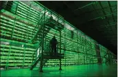  ??  ?? Long racks of Bitcoin mining rigs in Russia