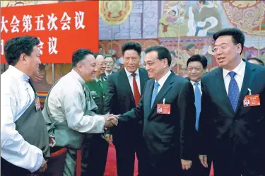  ?? WU ZHIYI / CHINA DAILY ?? Premier Li Keqiang meets with a deputy of the 12th National People’s Congress on Tuesday in the Great Hall of the People in Beijing while joining the Tibetan delegation for deliberati­ons on the Government Work Report, which Li delivered on Sunday. The...