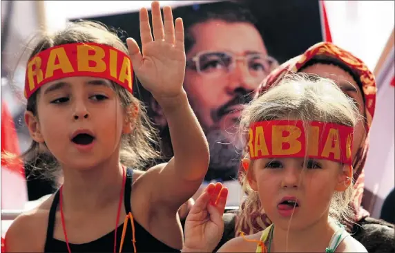  ?? — GETTY IMAGES ?? Children make the “Rabia sign” while taking part in a rally Saturday in Ankara to protest against the mass killings in Syria and Egypt. The “Rabia sign” has become a symbol to remember the massacre in Egypt at the Rabaa al-Adawiya Square.