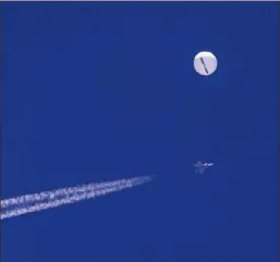  ?? Chad Fish via AP ?? In this photo provided by Chad Fish, a large balloon drifts above the Atlantic Ocean, just off the coast of South Carolina, with a fighter jet and its contrail seen below it, Feb. 4.