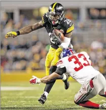  ?? JARED WICKHAM / ASSOCIATED PRESS ?? Steelers running back Le’Veon Bell runs through a tackle by Giants safety Andrew Adams. Bell rushed for 118 yards on 29 carries in Sunday’s 24-14 victory at Heinz Field.