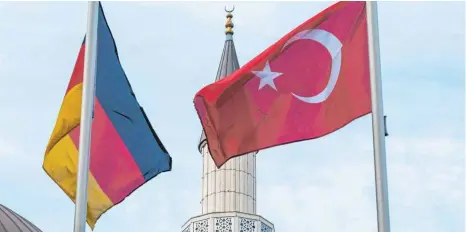  ?? FOTO: DPA ?? Eine deutsche und eine türkische Fahne vor einer Moschee in Duisburg-Marxloh. Nach Spionagevo­rwürfen gegen den türkischen Geheimdien­st MIT verlangen deutsche Politiker ein konsequent­es Vorgehen.