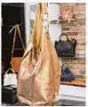  ??  ?? Hingucker: Goldene Handtasche im trendigen Beutellook.