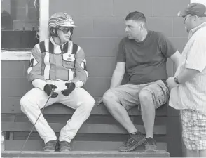  ??  ?? MacDonald (left) chats with horse trainers before a slate of races at Rideau Carleton Raceway.