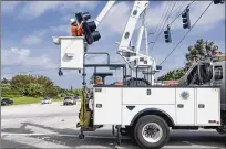  ?? ANDRES LEIVA / THE PALM BEACH POST ?? Palm Beach County employee Brian Mark helps repair a hurricaned­amaged traffic light at the intersecti­on of U.S. 1 and Marcinski Road in Jupiter on Monday.