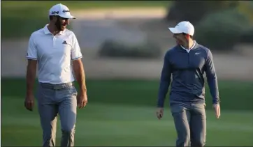  ?? The Associated Press ?? NO MORE GAMES: Dustin Johnson of the United States, left, and Rory McIlroy of Northern Ireland talk on the 10th fairway on Jan. 18, 2018, during the first round of the Abu Dhabi Championsh­ip in Abu Dhabi, United Arab Emirates. McIlroy will partner with Johnson in a charity match Sunday at Seminole that will be live golf’s return to television.